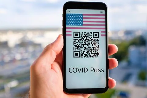 Covid pass with QR code with USA flag on the screen in smartphone in mans hand Stock Photos