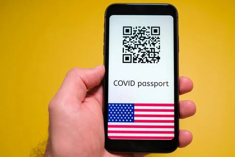 Covid pass with QR code with USA flag on the screen in smartphone in mans hand Foto stock