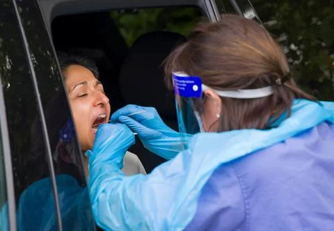 COVID testing centre with Asian BAME woman, UK Stock Photos