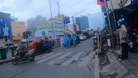 Covid workers spraying each other down on street with motorbikes and people Stock Footage 166893831