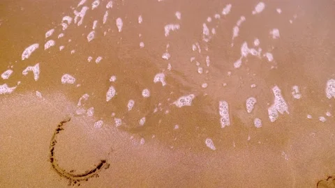 Covid is written on sand on beach. Wave erases coronavirus Stock Footage 213947634