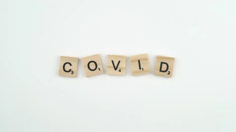 Covid Written In Scrabble Blocks. 4k Shot Of Hand Placing Wooden Game Stock Footage 156364651