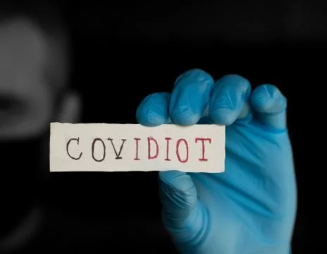 Covidiot Text, Masked Man holds the inscription, Covid-19 Concept Stock Photos
