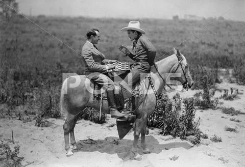 Cowboy and businessman playing checkers on horseback Stock Photos