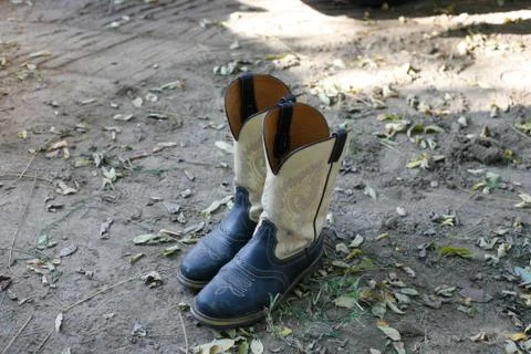 Cowboy boots on the ground Stock Photos