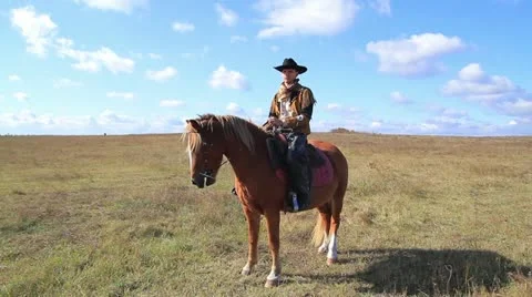 Cowboy gets down from horse Stock Footage 18348243