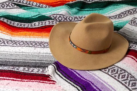 A cowboy hat on a colorful Southwestern design blanket in the background Stock Photos