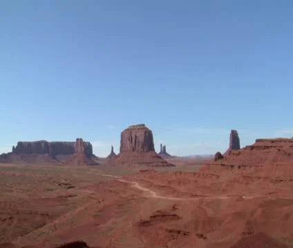 A cowboy on his horse rides to a Vista of Monument Valley Stock Footage