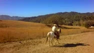 Cowboy On Horseback Traveling On Mountain Range On Sunny Day By Aerial Drone Stock Footage