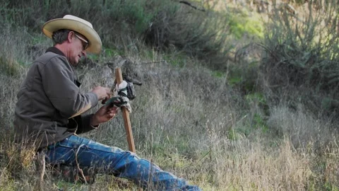 Cowboy Hunter Setting Up Wildlife Game Camera on Post Stock Footage 266803479