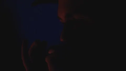 Cowboy plays the harmonica by a campfire at night in slow motion Stock Footage 128779651