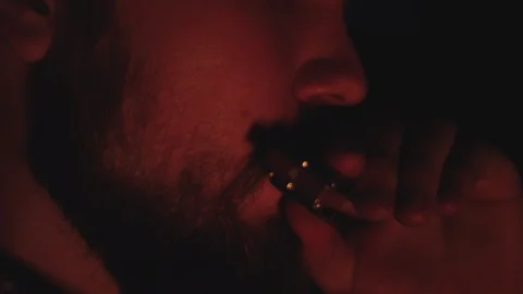Cowboy plays the harmonica by a campfire at night in slow motion Stock-Footage 128780075