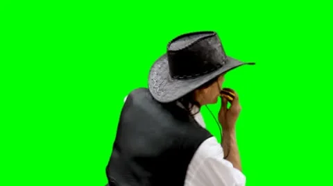 Cowboy plays on harmonica harp on greenscreen Stock Footage 10731532