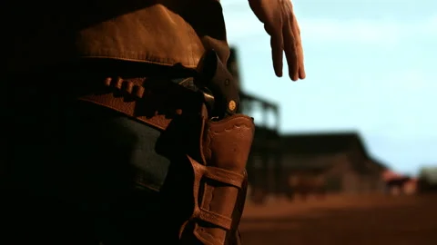Cowboy preparing to draw his gun during standoff, CU on hands and holster Stock Footage 194803138