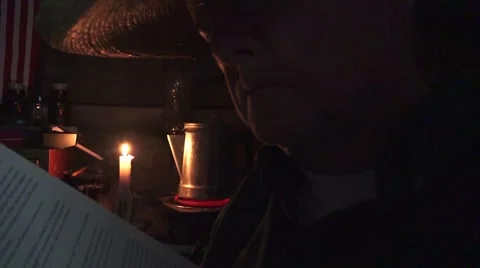 Cowboy reading by candle light 스톡 동영상 58800954