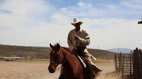 Cowboy riding up to a barn Video stock 64118835