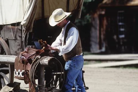 Cowboy Working On Saddle Stock Photos