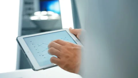 Coworkers analyzing and looking at graphs and charts in a tablet at modern Stockbeeldmateriaal 92278142