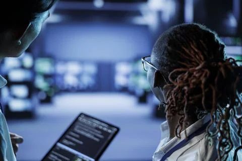 Coworkers code on tablet in data center 写真素材