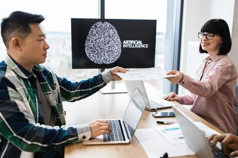 Coworkers collaborating on artificial intelligence project in modern office 写真素材