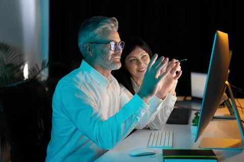 Coworkers Collaborating on Project with Computer in Modern Office Environment Stock Photos