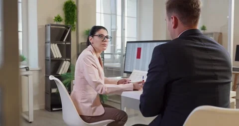Coworkers discussing data at computer in modern office during manager meeting Stock Footage 325604542