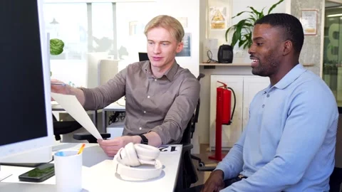 Coworkers discussing documents in modern office Stock Footage 301517461