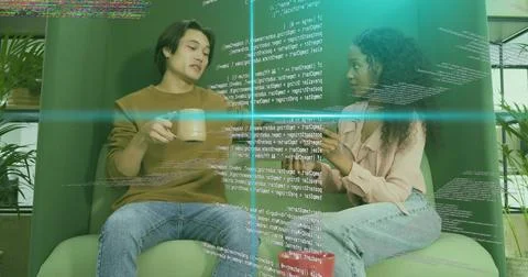 Coworkers discussing software code in break area, green chairs, coffee mugs and Foto stock