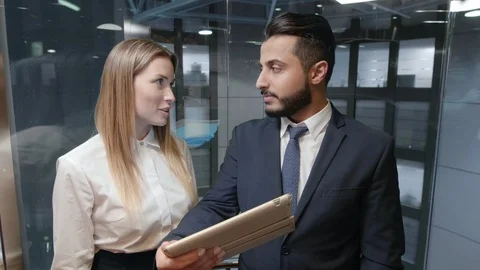 Coworkers in elevator with tablet computer Vidéo 100904617