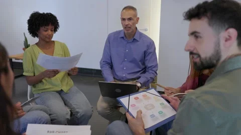 Coworkers engaged in active debate during an informal meeting at the office Stock Footage 345095500