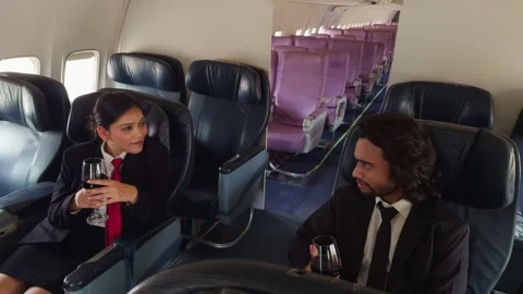 Coworkers enjoy drinks while chat inside a quiet airplane Stock Footage 301439698