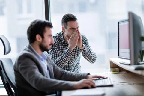 Coworkers having problem with computer in office Stock Photos