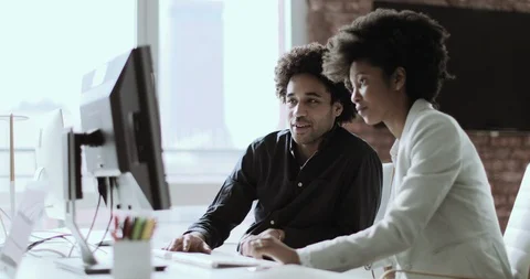 Coworkers looking at a desktop computer together Stock Footage 99698550