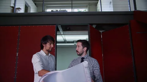 Coworkers looking over plan Stock Footage 62347306