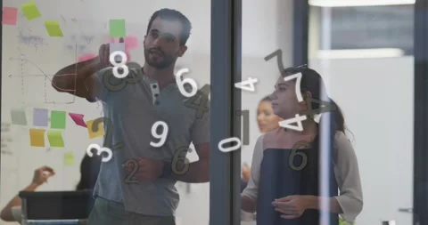 Coworkers picking up sticky note, annotating business graph on glass and placing Video stock 317275315