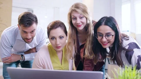 Coworkers Smiling At Computer Screen Happy News On Social Media Company Stocks Stock Footage