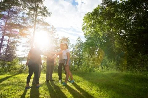 Coworkers Stacking Fists While Standing In Forest On Sunny Day Stock Photos
