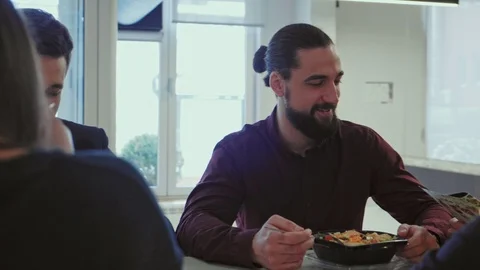 Coworkers talking while eating lunch in the office Stock Footage 101744984