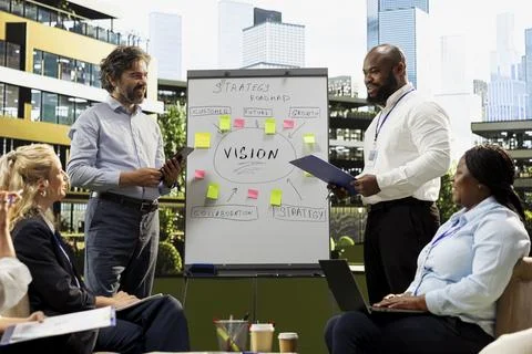 Coworkers team presenting vision roadmap on whiteboard at outdoor meeting Stock Photos