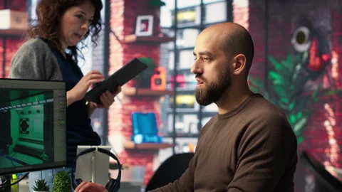 Coworkers using AI chatbot interface to generate video game spaceship Video stock 308605206