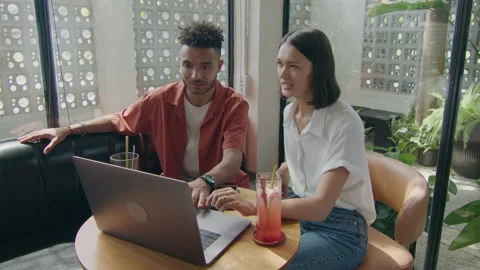 Coworkers Using Laptop on Catch-Up in Cafe Stock Footage 235772652