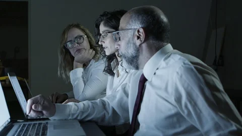 Coworkers using laptops and discussing project Stock Footage 120592949
