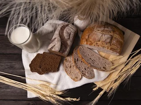 A cozy arrangement of assorted bread varieties with a glass of milk Stock Photos