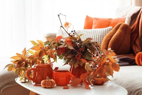 Cozy Autumn Table Setting with Orange Teaware and Fall Leaves Displayed Indoo Stock Photos