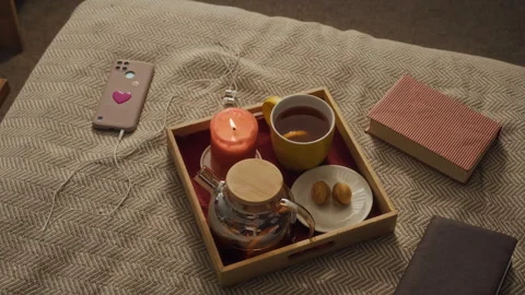 Cozy Autumn Tea Tray with Burning Candle and Book Lying on Bed for Relaxation Stock Footage 340313190