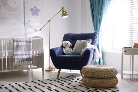 Cozy baby room interior with comfortable armchair Stock Photos