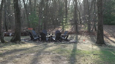 Cozy Backyard Fire Pit with Wooden Chairs and String Lights in Morning Forest Stock Footage 333018484