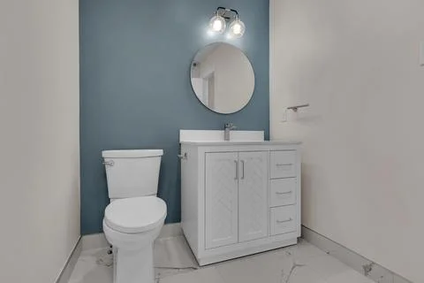 Cozy bathroom featuring blue wall and white fixtures, blending serenity and.. Stock-Fotos