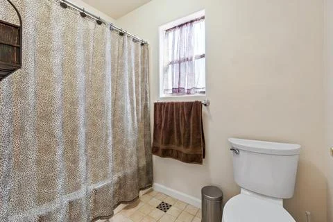 Cozy bathroom featuring a leopard print shower curtain and earthy tones Stock Photos