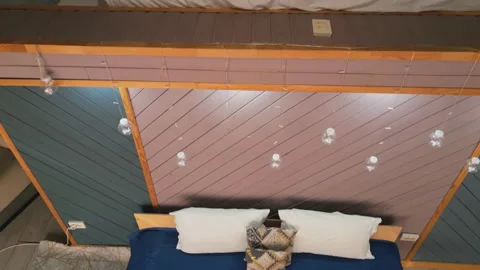 Cozy bedroom interior with blue bedding and warm wooden walls. Stock Footage 319019379